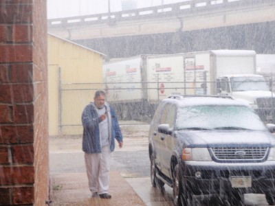 Carlos taking a picture of his truck in the snow.