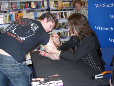 Ozzy signing my arm (notice someone ringing Tony Dennis)